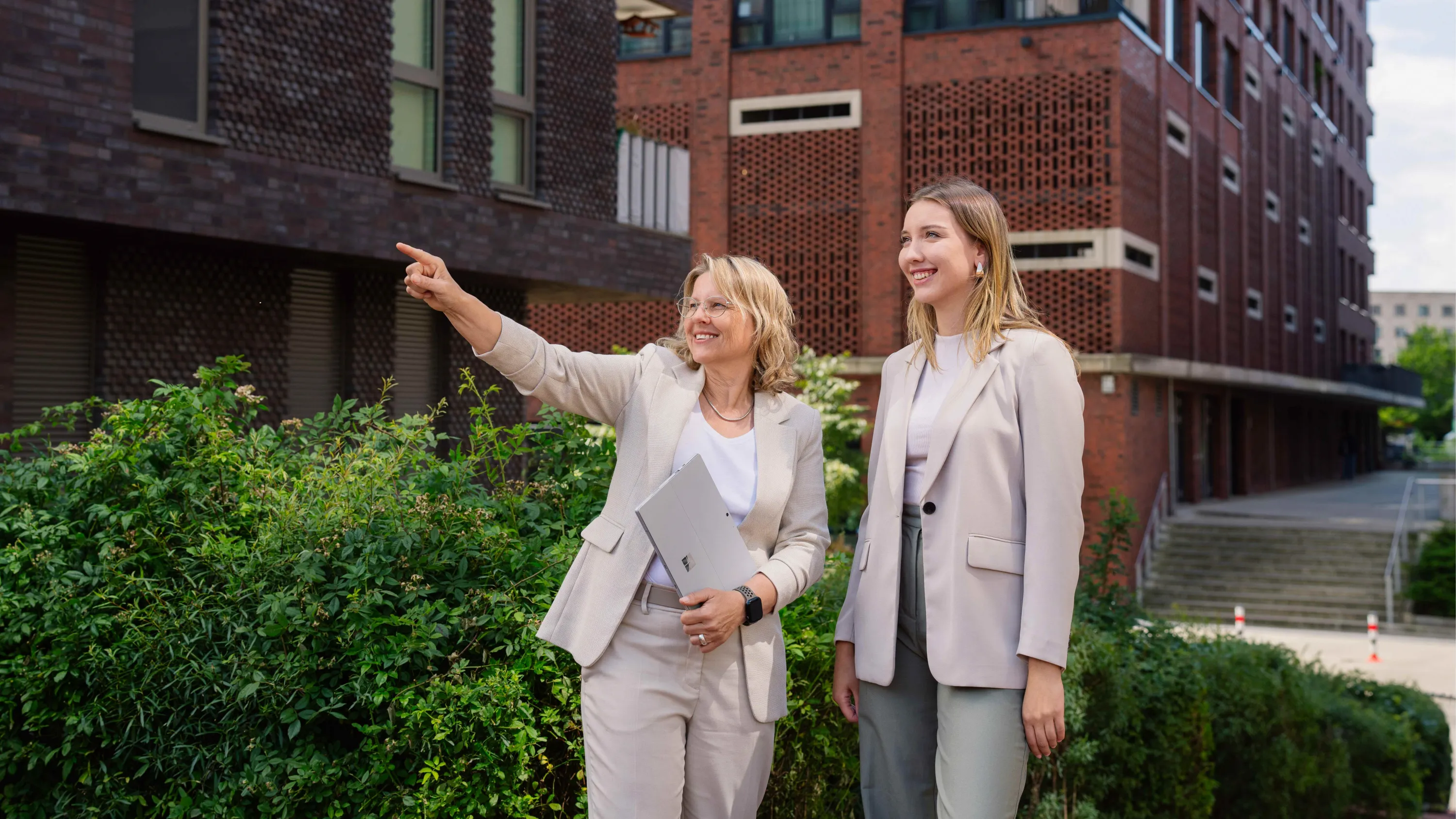 Zwei Frauen schauen sich eine FRANK Immobilie von außen an