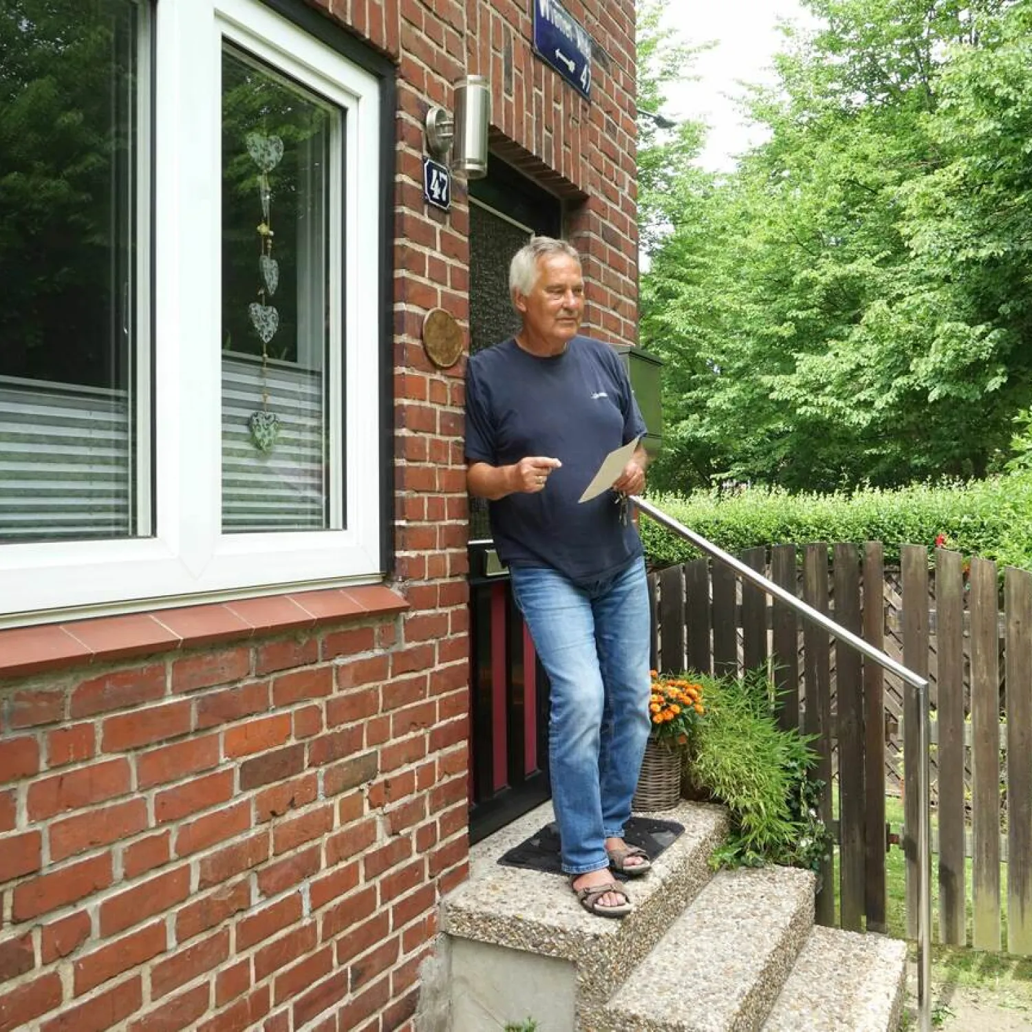 Verwaltungsbeirat vor dem Hauseingang seines von FRANK-WEG-Verwaltung gemanagten Wohnquartiers.