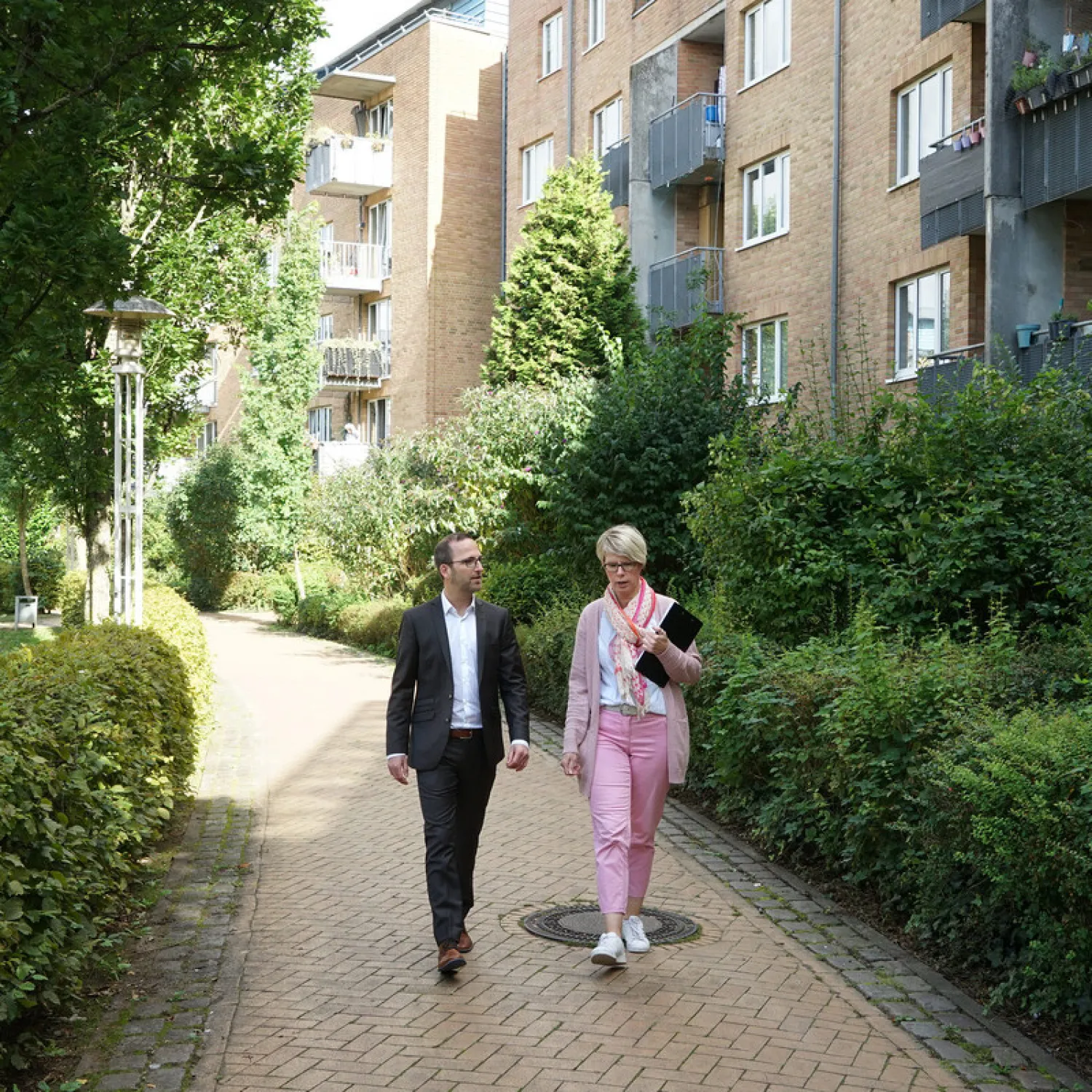 FRANK Gustav-Schatz-Hof: ruhiger Innenhof mit Sitzbänken und Grünflächen für Senioren und Bewohner*innen.