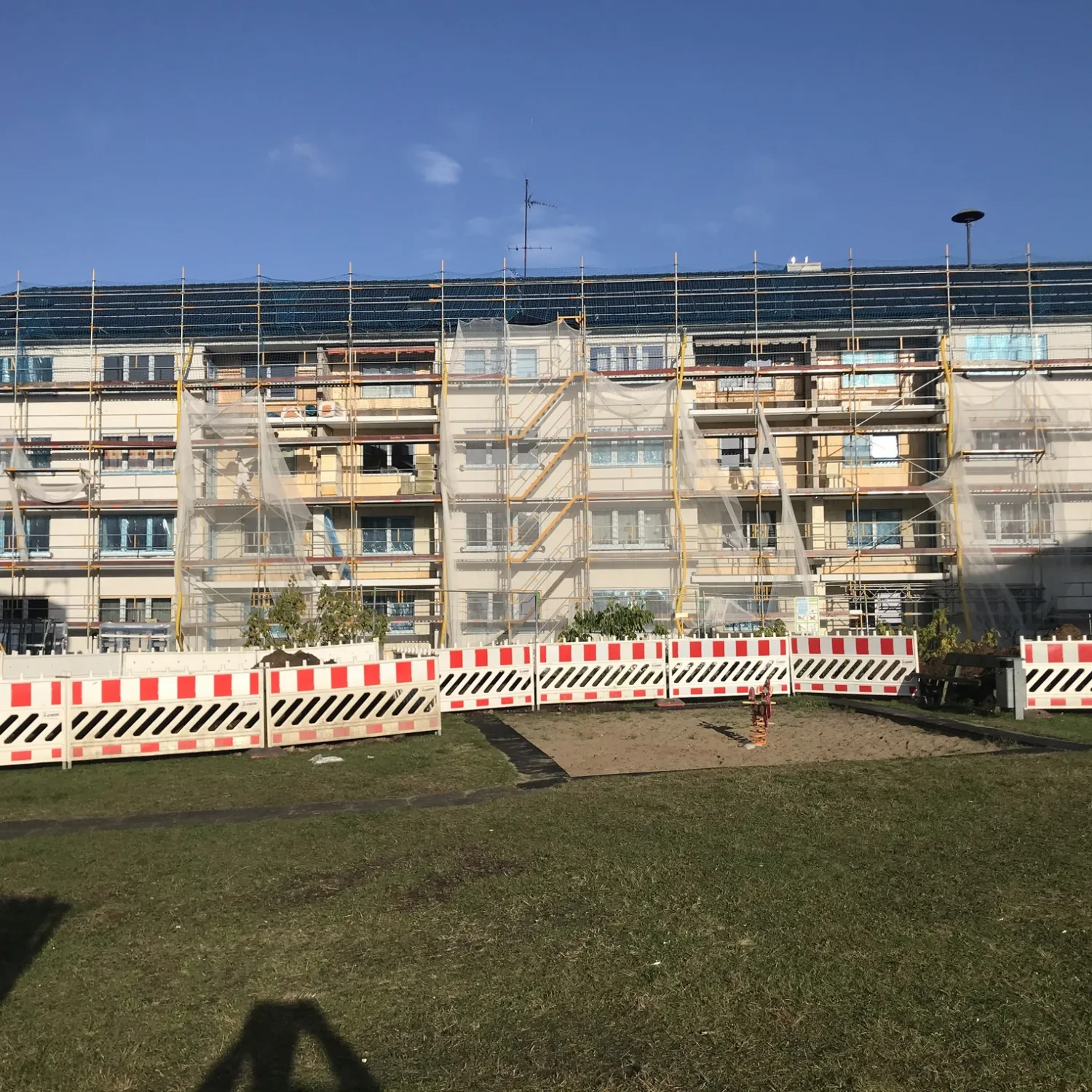 Ein Mehrfamilienhaus ist für die energetische Sanierung durch FRANK eingerüstet.