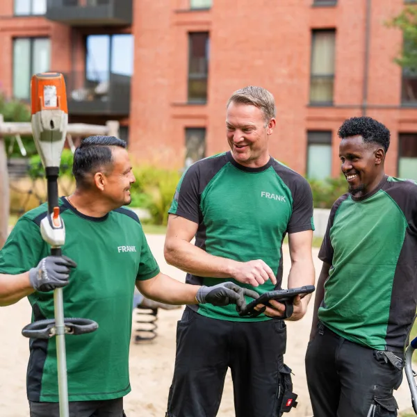 Ein FRANK-Mitarbeiter mäht Rasen mit einem Aufsitzmäher.